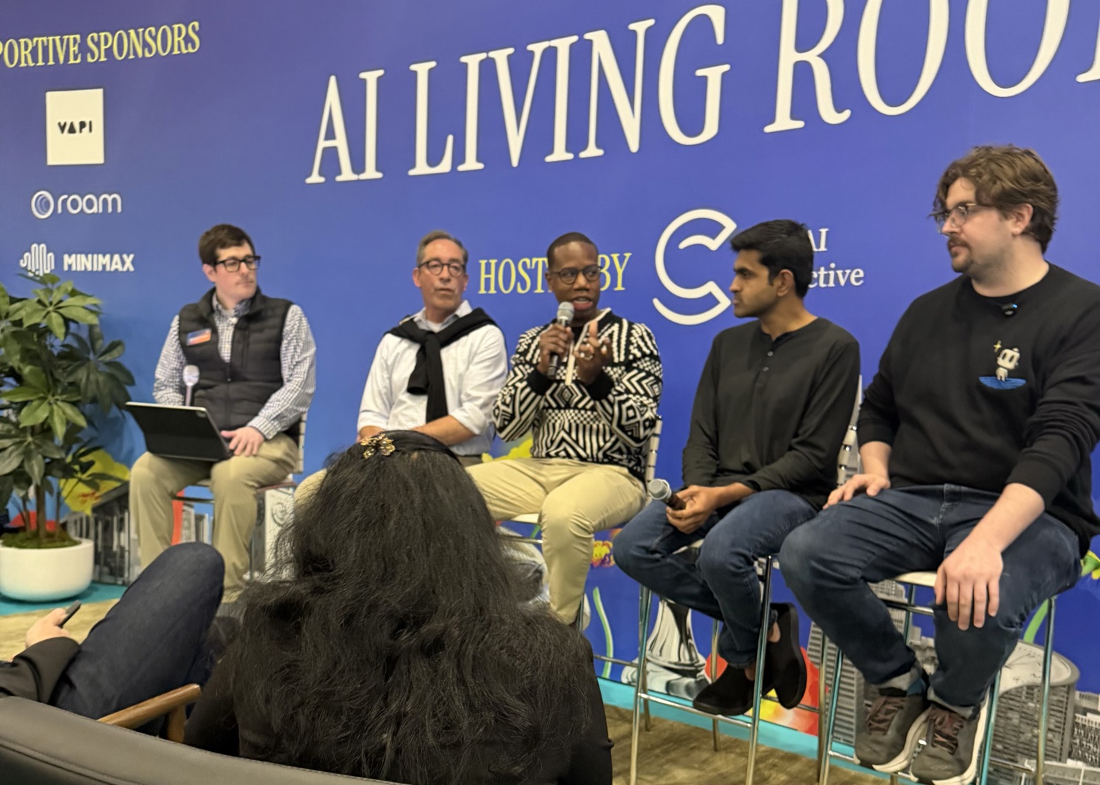 Tyrone Ross speaking on the AI Living Room panel at Human X while fellow panelists listen
