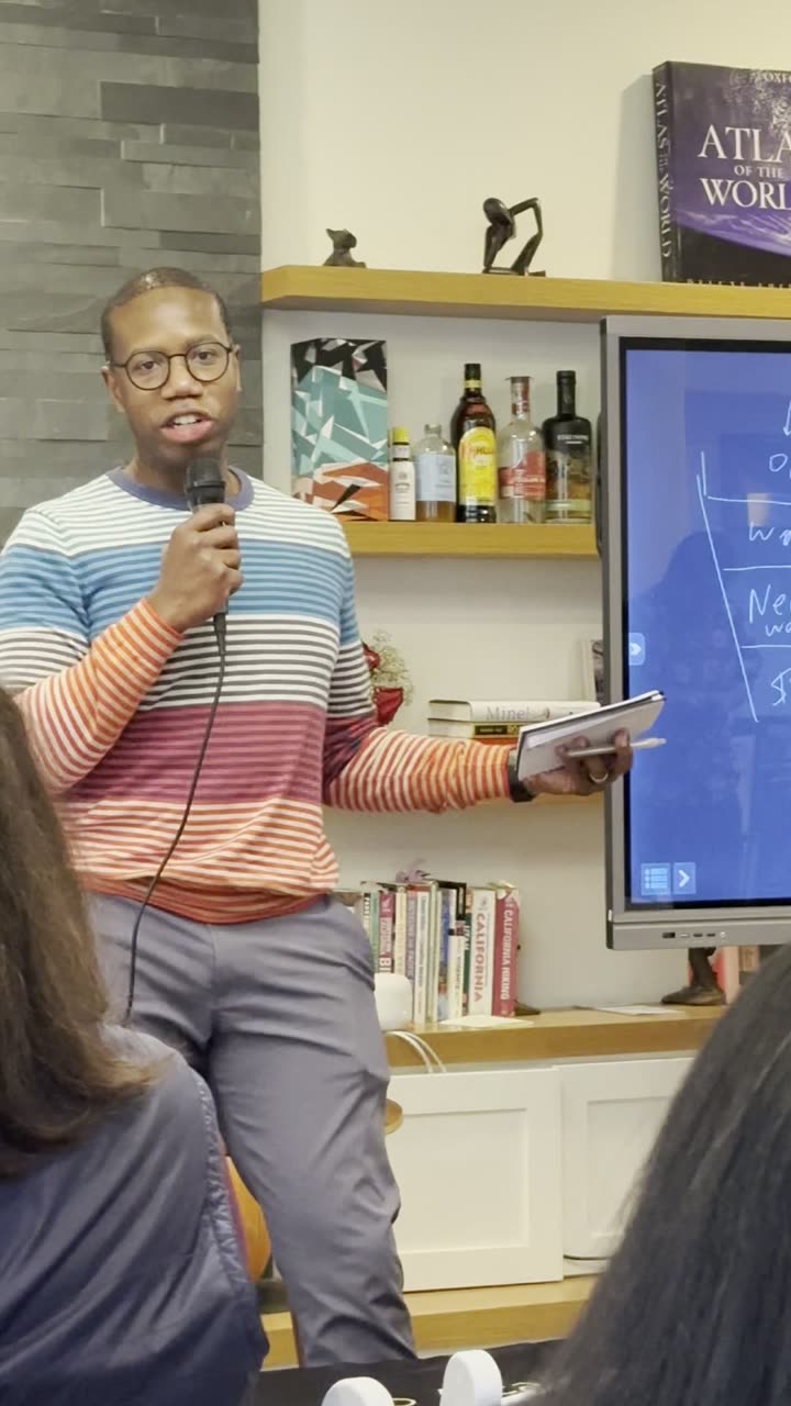 Tyrone Ross delivering a keynote with microphone and notes in hand